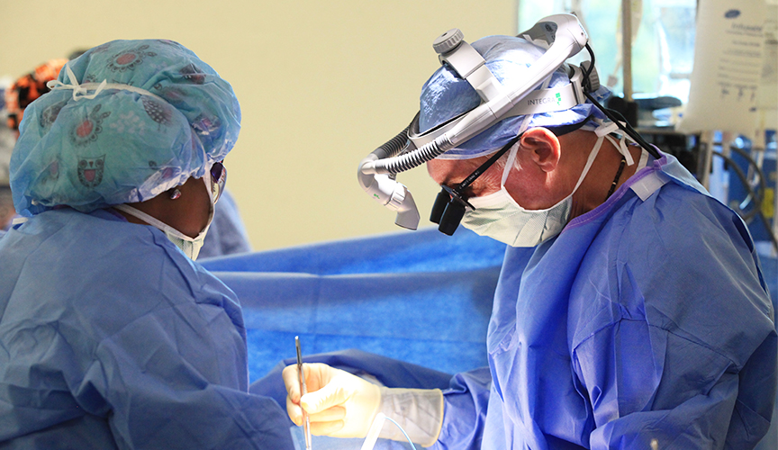 A cardiac surgeon performs congenital heart surgery.
